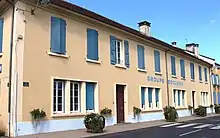 Photographie en couleurs, représentant un bâtiment (une école).