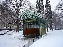 Photo en couleur d'un petit édifice avec des panneaux pleins et du verre, sous la neige