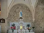 Autel et tabernacle en marbre surmontés d'une statue de Notre-Dame de Lourdes