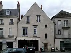 Photographie en couleurs de la façade d'un bâtiment montrant des vestiges de baies en plein cintre.