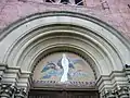 Tympan du portail de l'église où est représentée l'Immaculée Conception. La fresque a été réalisée sur le tympan en 1954 pour fêter le centenaire du dogme de l'Immaculée Conception proclamé par l'église catholique le 8 décembre 1854 par le pape Pie IX.