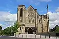 Façade d'une église avec son clocher sur le côté gauche.