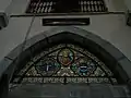 Le vitrail de l'entrée de l'Église Saint-Jean l'Évangéliste de Bertren où est représentée le portait de Prosper-Marie Billère, son blason et celui du village de Bertren auparavant ?