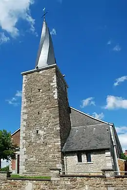 La tour du XVIe siècle surmontée du clocher tors de 1840 avec le porche néoroman à droite.