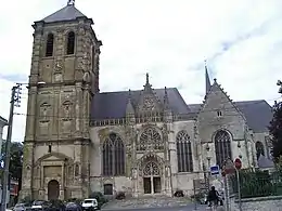 Photo d'une église de style gothique avec un clocher imposant ressemblant à une tour.