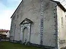 L'ancienne entrée de l'église avec une stèle d'une tombe