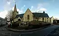 Vue général de l'église avec l'ancienne croix de cimetière en avant plan.