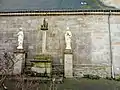 Façade nord avec les statues de la Vierge et de Saint Jean encadrant un calvaire.