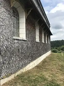 Tôle et surprotection de bois sur un côté de l'église.