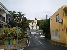 Photographie de la rue de l'église de Deshaies avec l'église en arrière-plan.