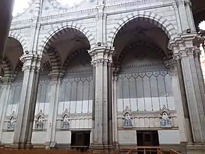 Photographie couleur latérale des arcs séparant la nef centrale des bas-côtés d'une église.