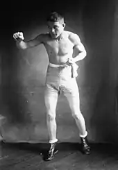 Photographie en noir et blanc d'un boxeur en garde à l'entraînement.