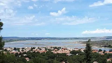 Étang de Lapalme depuis les hauteurs de la Franqui. Au loin, sous les éoliennes: la ville de La Palme.