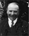 Photographie noir et blanc au format d'identité d'un homme cravaté.