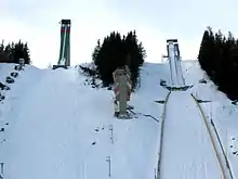 Deux tremplins de saut à ski enneigés vu de face