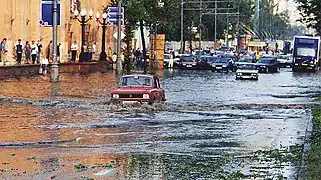 Une Moskvitch-412IE surmonte un obstacle d'eau après la pluie et de la grêle à Moscou à l'été 1996.