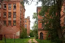 À gauche, le bas de l’ancienne façade ornée mais croulante a été réparée par un simple mur plein.