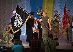 Vladislav Klotchov recevant un drapeau pour le 93e lors du 75e anniversaire de l'unité,