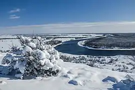 Le méandre d'un fleuve dans un paysage enneigé.