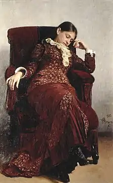 Portrait d'une femme brune endormie dans un fauteuil.