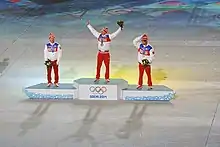 Vue de loin du podium des 50 kilomètres des Jeux de Sotchi, le vainqueur levant les bras en l'air.