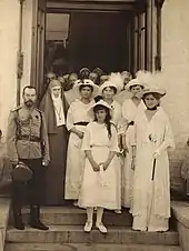 Photographie en noir et blanc montrant un groupe de personnes dans l'entrée d'un bâtiment.