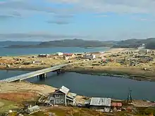 maison sur un promontoire dominant une rivière, un pont et un estuaire.