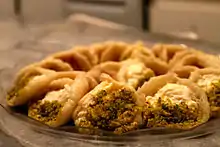 Plat de qatayef, dessert traditionnel en période de ramadan. Il s'agit d'une petite pâtisserie de pâte fourrée à la crème et à la poudre de pistache.