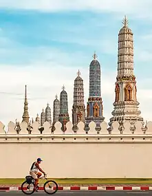 Un cycliste défile à côté du Wat Phra Kaeo (Bangkok). Septembre 2022.