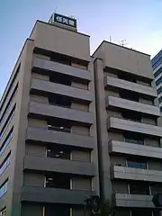 Photo de la partie haute d'un bâtiment beige comportant au moins six étages.