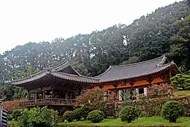 Photographie d'un temple composé de deux bâtiments, entourés par des arbres.
