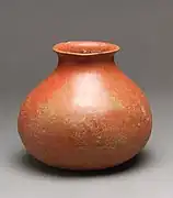 Photographie d'un poterie en forme de vase, posée sur un fond neutre.