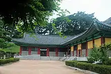 Photographie d'une école Sŏwon, deux bâtiments sont visibles, entourés par de la verdure.