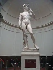 Statue en marbre d'un homme nu début sur un piédestal