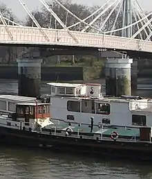 Une péniche passant en dessous d'un pont.