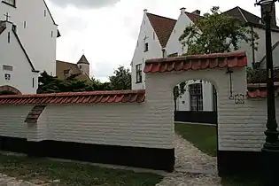 Les deux pignons de la no 20 avec à gauche la chapelle accotée à la façade latérale du complexe no 22 (bordant le côté ouest de l’enclos central). Plus loin, au centre gauche, bâtiments du couvent de bénédictines avec sa tour carrée.