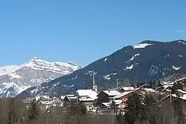 Photographie numérique couleur. Village au toits eneigés dans une montagne. Arrière-plans montagnes eneigées.