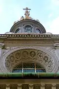 Une décoration de vitrail et la croix sur le dome de la chapelle