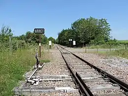 Le PN11 près de l'ancienne gare vu en direction de Clamecy. Au premier plan, la timonerie de l'aiguille et le signal « ARRÊT » imposé au conducteur du train.