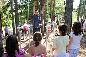 Pascal Bouchard du collectif d'artistes La Corvée dirigeant l'Orchestre suspendu exécuté par les élèves du Camp musical du Saguenay—Lac-Saint-Jean.