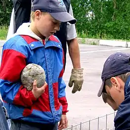 Un élève apporte sa pierre à installer dans le Tacon Site.