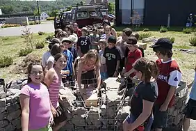 Les élèves de l'école Saint-Joseph de La Baie au Saguenay installent le coffre contenant les œufs d'or dans le Tacon Site de la Vallée Glaciaire