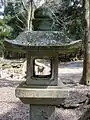 Lanterne de pierre menant au sanctuaire encadrant un cerf du parc de Nara.