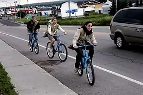 Les Portageurs à vélo transportant leur pierre de granite dans les rues de Chambord.