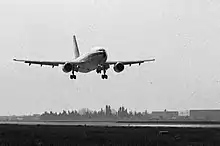 Photo noir et blanc d'un avion à basse altitude.