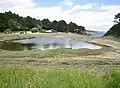 La lagune en arrière du cordon littoral de la grève du Bindy.