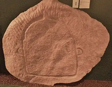 Gravure en creux représentant peut-être une idole trouvée sur une des pierres du dolmen à couloir de l'île Longue en Baden (Musée de préhistoire de Carnac)