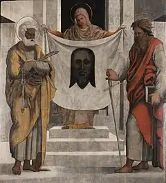 Femme présentant un drap sur lequel est représenté le visage du Christ, entourée de deux hommes.