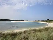 La plage du Guillec (rive droite de l'estuaire du Guillec), à l'arrière-plan le port de Moguériec