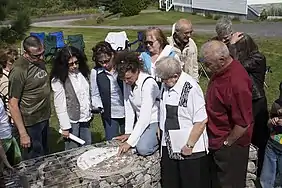 Le Tacon Site de la Famille appartient à la municipalité de Saint-Charles-de-Bourget. On voit l'artiste Claire Maltais montrant l'arbre généalogique de la famille Maltais.